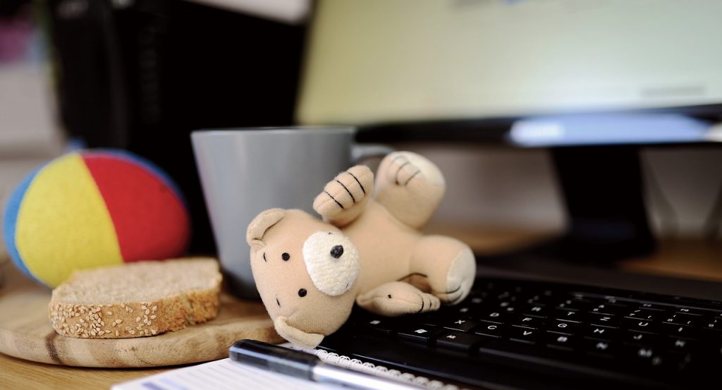 Teddybär auf der Computertastatur, Braot auf dem Schreibtisch: Alltag im Homeoffice.
